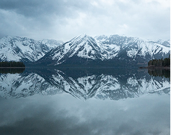 Landscape view of Snowy Grand Teton Mountains over a misty lake